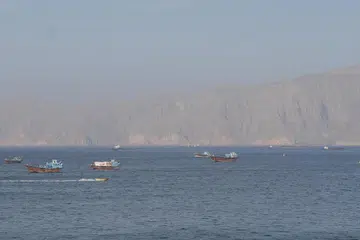 Kapal dan kapal tangki belayar di Selat Hormuz di luar perairan pantai Musandam, Oman, pada 18 April.