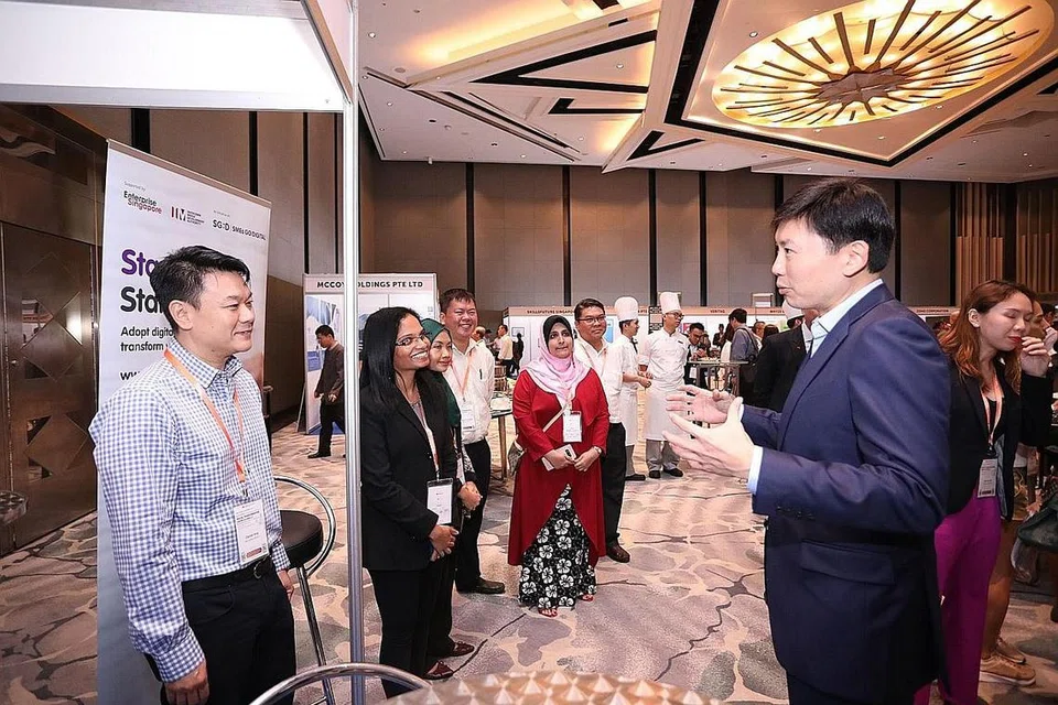 SEDIA WADAH SOKONGAN BUAT SME: Encik Chee (kanan) bercakap dengan wakil Pusat SME@DPPMS di Sidang Pusat SME, Pusat Konvensyen Raffles City, semalam. - Foto ENTERPRISE SINGAPORE