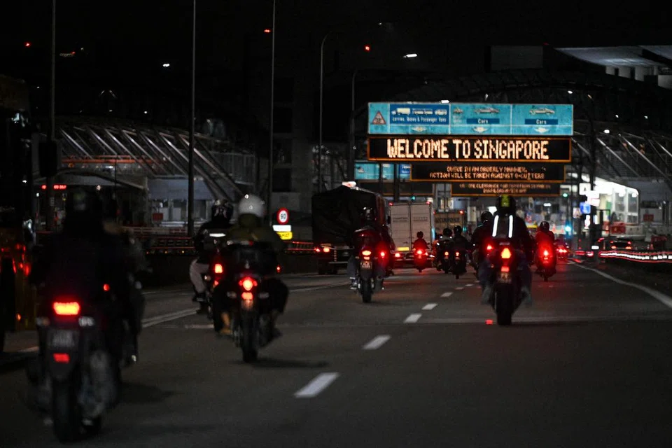 Warga Malaysia yang menunggang motosikal menuju ke Pusat Pemeriksaan Tuas.