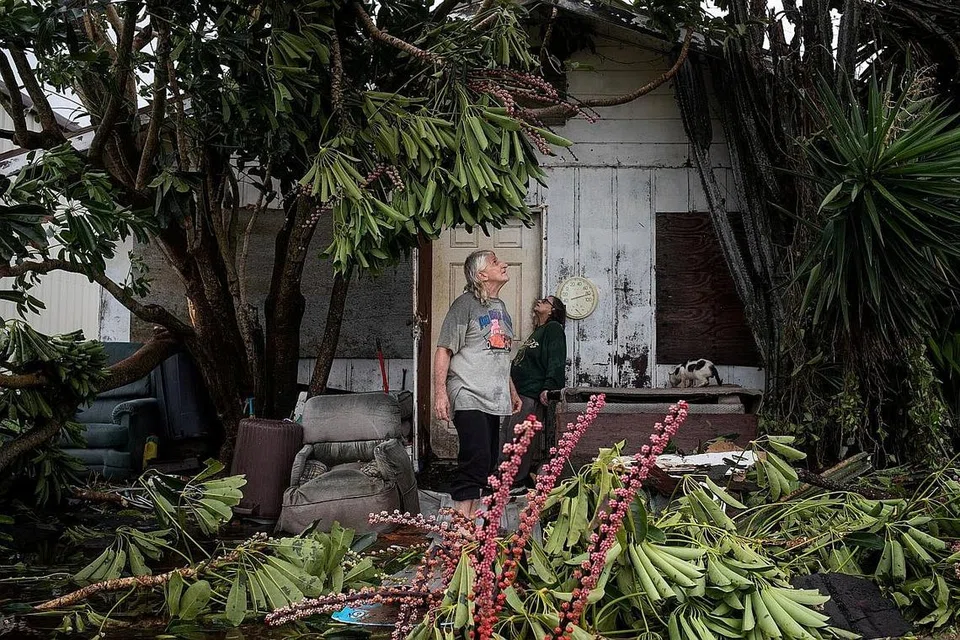 PERIKSA KEMUSNAHAN: Encik Charles Pecce 70 tahun, dan isteri Cik Sharon Becca 76 tahun meninjau keadaan rumah mereka yang musnah akibat Taufan Hanna di Port Mansfield Texas. - Foto REUTERS