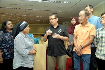 SOKONGAN GERAKAN BURUH KEPADA PEKERJA PEMBERSIHAN: Encik Zainal Sapari (berbaju hitam) berbual dengan Cik Junaina Ismail (dua dari kiri) dan beberapa pekerja pembersihan di ibu pejabat Kongres Kesatuan Sekerja Kebangsaan (NTUC), semalam. - Foto M.O. SALLEH