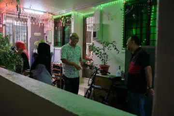 CETUS PELUANG BERMESRA: (Gambar atas) Encik Sani Romli (tengah) berkata menghiasi koridor dengan pelbagai jenis lampu lap-lip membolehkan beliau mengenali dengan lebih dekat jiran di sepanjang koridor itu. 