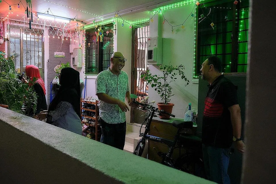 CETUS PELUANG BERMESRA: (Gambar atas) Encik Sani Romli (tengah) berkata menghiasi koridor dengan pelbagai jenis lampu lap-lip membolehkan beliau mengenali dengan lebih dekat jiran di sepanjang koridor itu. 