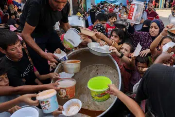 DAPATKAN MAKANAN: Kanak-kanak Palestin menadah bekas masing-masing untuk mendapatkan makanan. Situasi di Gaza sekarang semakin sukar untuk menyokong usaha-usaha kemanusiaan termasuk menghulurkan makanan dan minuman di sana.