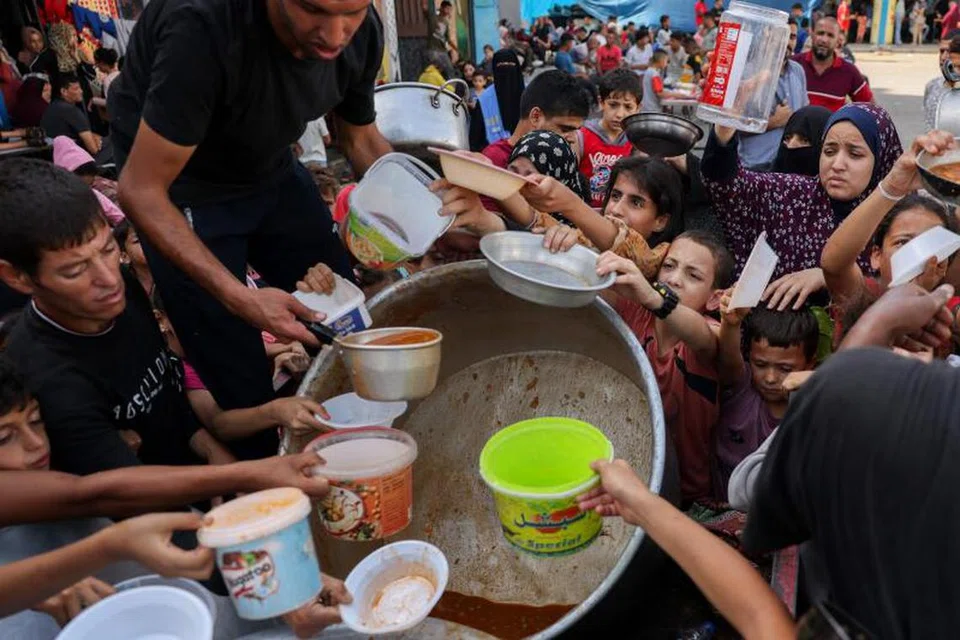 DAPATKAN MAKANAN: Kanak-kanak Palestin menadah bekas masing-masing untuk mendapatkan makanan. Situasi di Gaza sekarang semakin sukar untuk menyokong usaha-usaha kemanusiaan termasuk menghulurkan makanan dan minuman di sana.