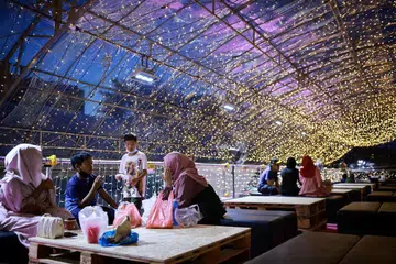 Pengunjung beristirahat semasa ke Bazar Geylang Serai 2023.