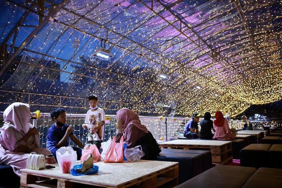 Pengunjung beristirahat semasa ke Bazar Geylang Serai 2023.