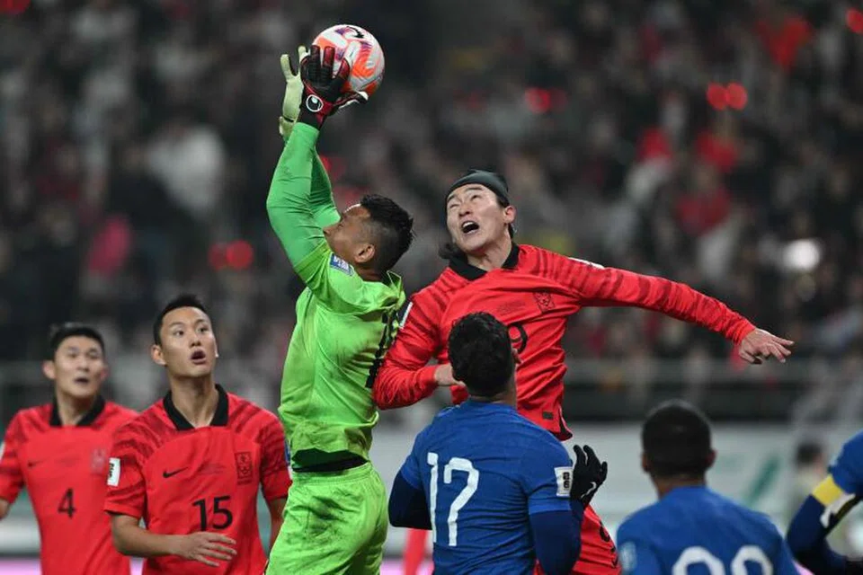 TANGKAS: Penjaga gol Singapura, Hassan Sunny, menangkap bola mendahului penyerang Korea Selatan, Cho Gue-sung, dalam aksi pembukaan pusingan kedua Kelayakan Piala Dunia di Stadium Piala Dunia Seoul pada Khamis. 