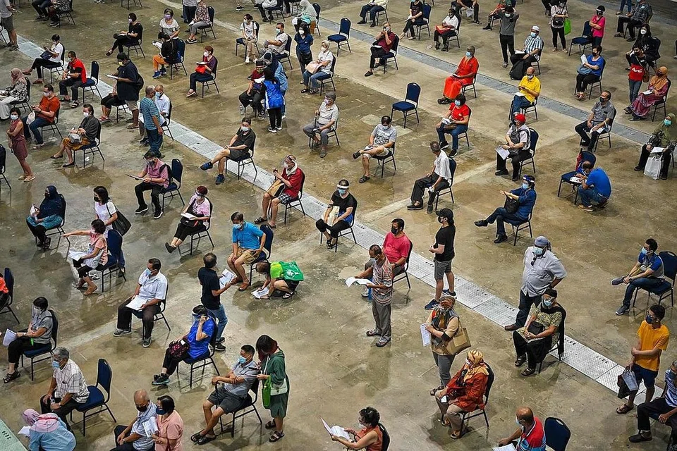PUSAT VAKSINASI MEGA: Orang ramai beratur di salah sebuah pusat vaksinasi mega di Malaysia, Pusat Dagangan Dunia Kuala Lumpur, baru-baru ini untuk mendapatkan suntikan vaksin Covid-19 mereka. - Foto AFP