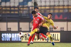 Pasukan Singa (jersi merah) cuba mengatasi asakan pemain Harimau Malaya ketika perlawanan Kumpulan A Piala Asean FIFA. Singa akhirnya ditundukkan 6-0. Keputusan itu bermakna Singa tersingkir daripada kejohanan tersebut