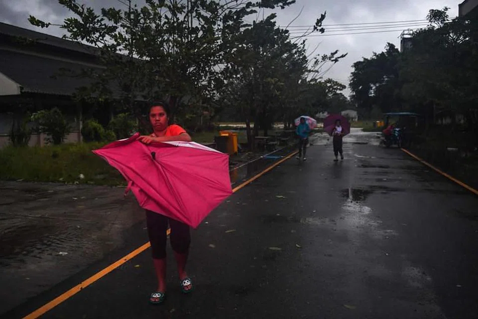 RIBUT PABUK: Seorang wanita dengan payungnya yang rosak di luar sebuah pusat pemindahan selepas ribut tropika Pabuk melanda bahagian selatan Thailand.