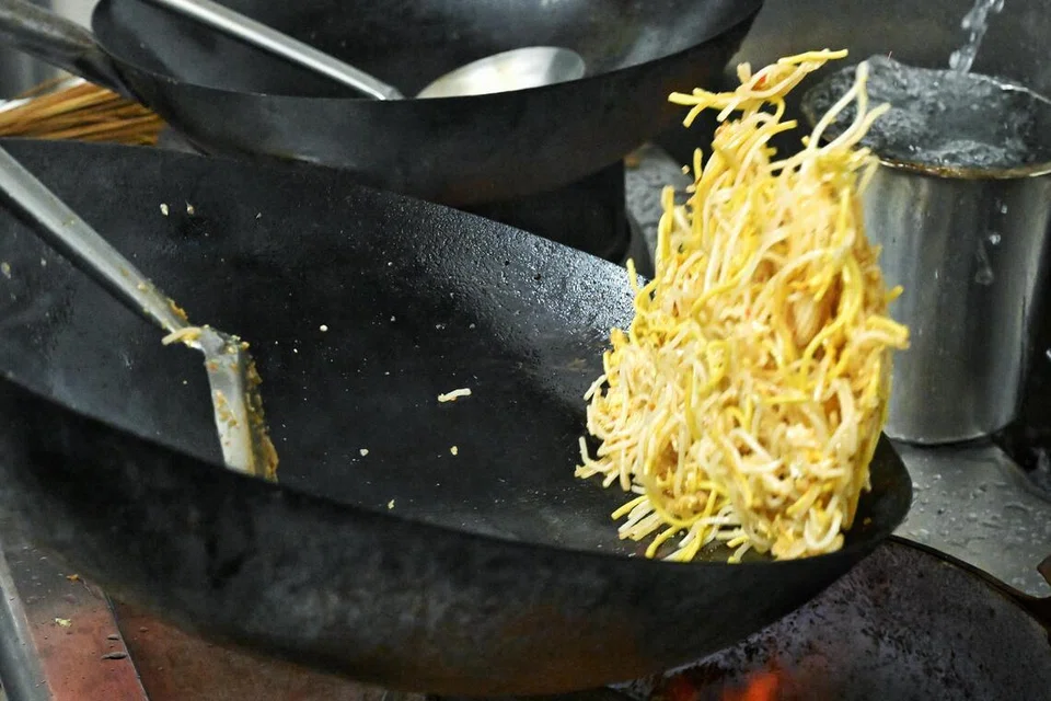 Mi dan sotong digaul bersama menggunakan api besar dengan gerakan pantas untuk menghasilkan aroma ‘wok hei’, yang menjadi ciri utama hidangan ini.