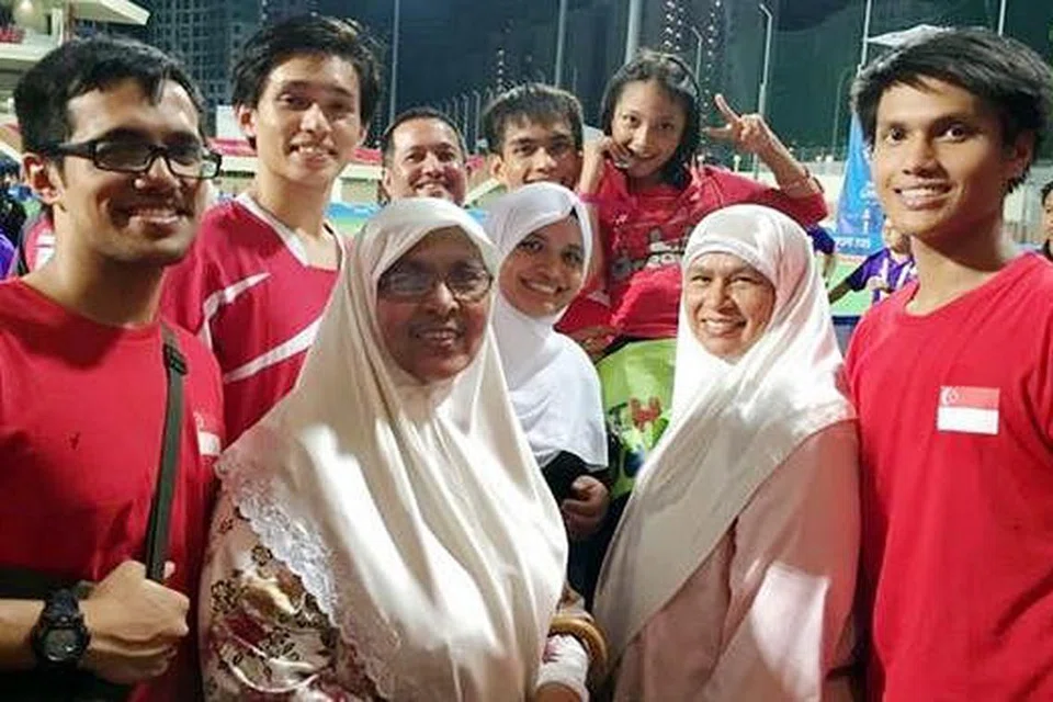 KONGSI KEJAYAAN: Muhammad Haseef Salim (tengah, belakang), yang mendukung adiknya, bergambar dengan anggota keluarga selepas pertarungan akhir hoki menentang Malaysia. Di kanannya ialah bapanya, Salim Mohamed Nasir, manakala ibunya, Habibah Husein (dua dari kanan) - Foto ihsan MUHAMMAD HASEEF SALIM