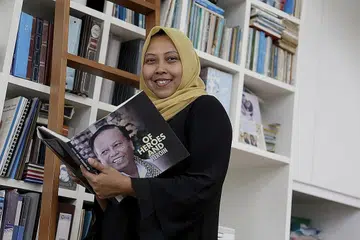 JASA AYAH: Ayahnya, Allahyarham Harun Abdul Ghani, yang gambarnya di buku yang dipegang Cik Haslinda (kiri), merupakan antara orang yang mendorongnya untuk teruskan usaha membantu anak-anak pesalah dadah.