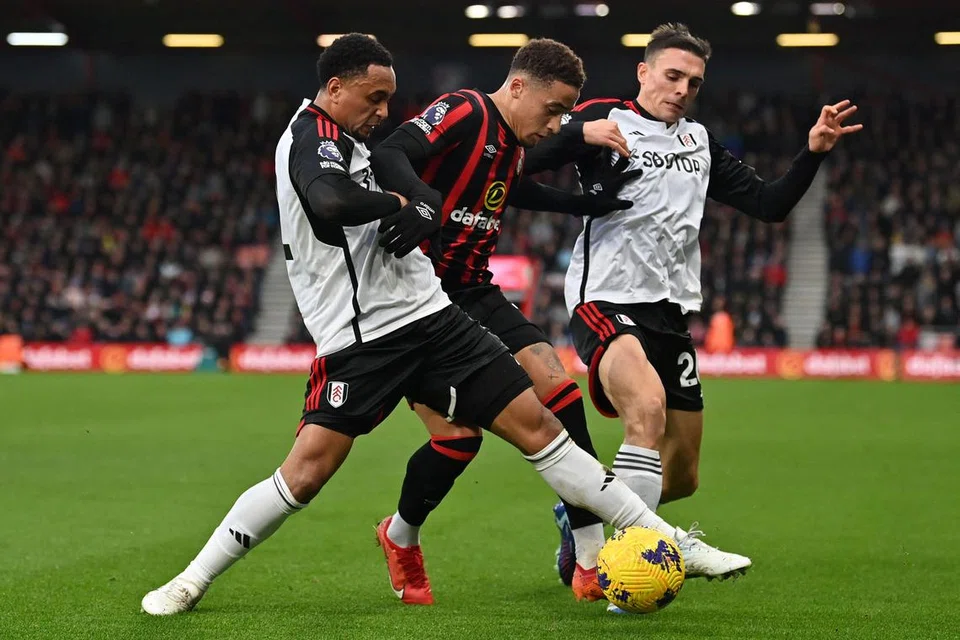 TINGKATKAN PERSEMBAHAN: Pemain Fulham,  Kenny Tete (kiri) dan Joao Palhinha (kanan), cuba membendung pergerakan pemain Bournemouth, Marcus Tavernier ketika perlawanan yang menyaksikan Fulham tewas 3-0 baru-baru ini.