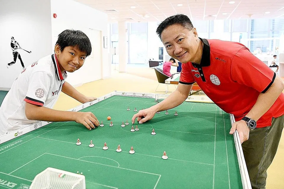 ANAK TURUT BERMAIN: Encik Tan Kok Wee (kanan) turut menarik anak keduanya, Tan Yi De, bermain bola sepak meja bersamanya sekurang-kurangnya sekali minggu. - Foto-foto BM oleh KHALID BABA