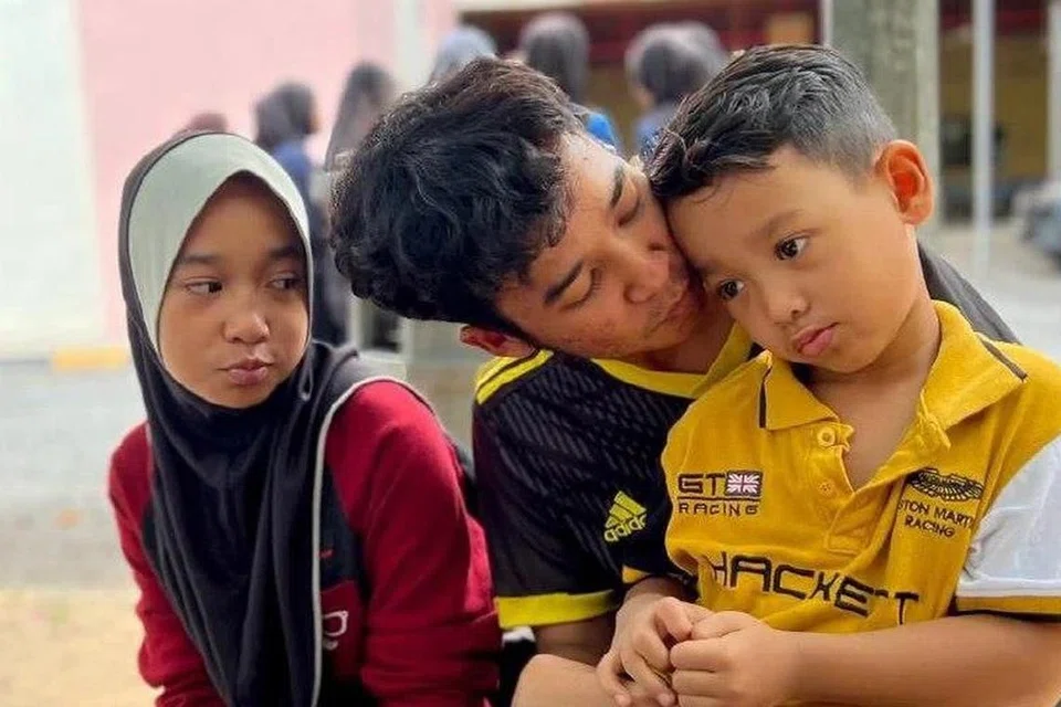 JAGA ADIK: Muhammad Amirul Ikhwan (tengah) bersama dua adiknya. Dia berkata tidak akan berpisah dengan mereka walau apapun terjadi. 