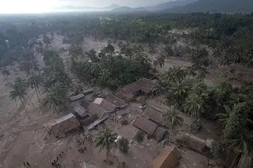 TERTIMBUS: Pemandangan dari udara menunjukkan rumah-rumah ditimbus debu gunung berapi selepas meletusnya Gunung Semeru di kawasan Lumajang, Jawa Timur kelmarin. - Foto ANTARA / REUTERS