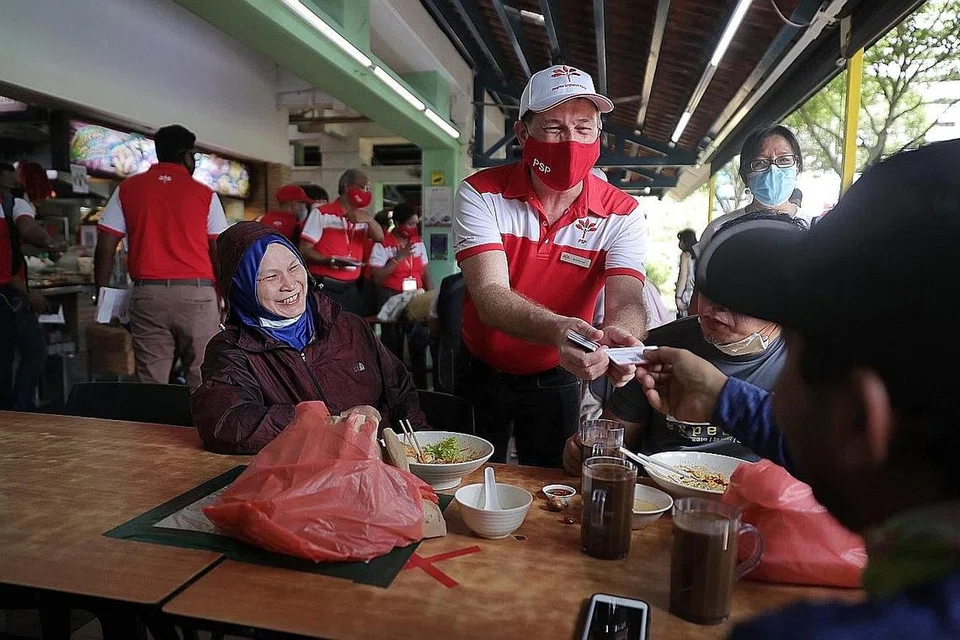 GIAT BERKEMPEN: Calon Parti Kemajuan Singapura (PSP) bagi GRC Nee Soon, Encik Bradley Bowyer menyerahkan risalah parti di kedai kopi di Blok 846 Yishun Ring Road semalam. - Foto BH oleh GAVIN FOO