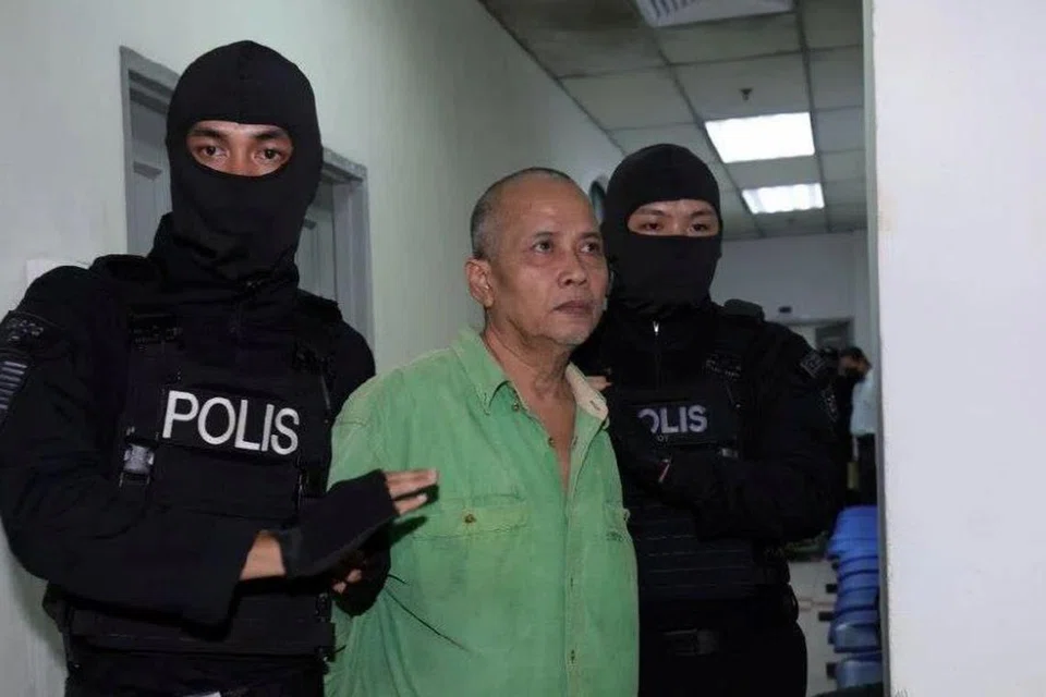 Bapa penyerang Balai Polis Ulu Tiram, Johor, Radin Imran Radin Mohd Yassin, dikawal rapi polis ketika tiba di Kompleks Mahkamah Johor Bahru pada 2 September. 