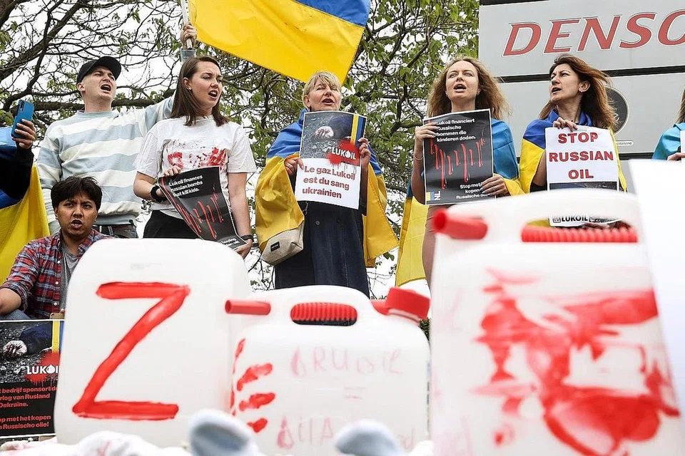 BANTAHAN: Penunjuk perasaan mengadakan bantahan di depan ibu pejabat syarikat minyak Russia, Lukoil, di Brussels, ekoran pencerobohan Russia ke atas Ukraine. - Foto AFP