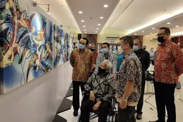 SUMBANGAN DIHARGAI: Encik Sarkasi Said (berkerusi roda) melihat lukisan batik beliau yang dipamer di bangunan Jamiyah dengan diiringi Encik Edwin Tong dan Dr Mohd Hasbi Abu Bakar (kiri dan kanan beliau). - Foto BH oleh NUR DHUHA ESOOF