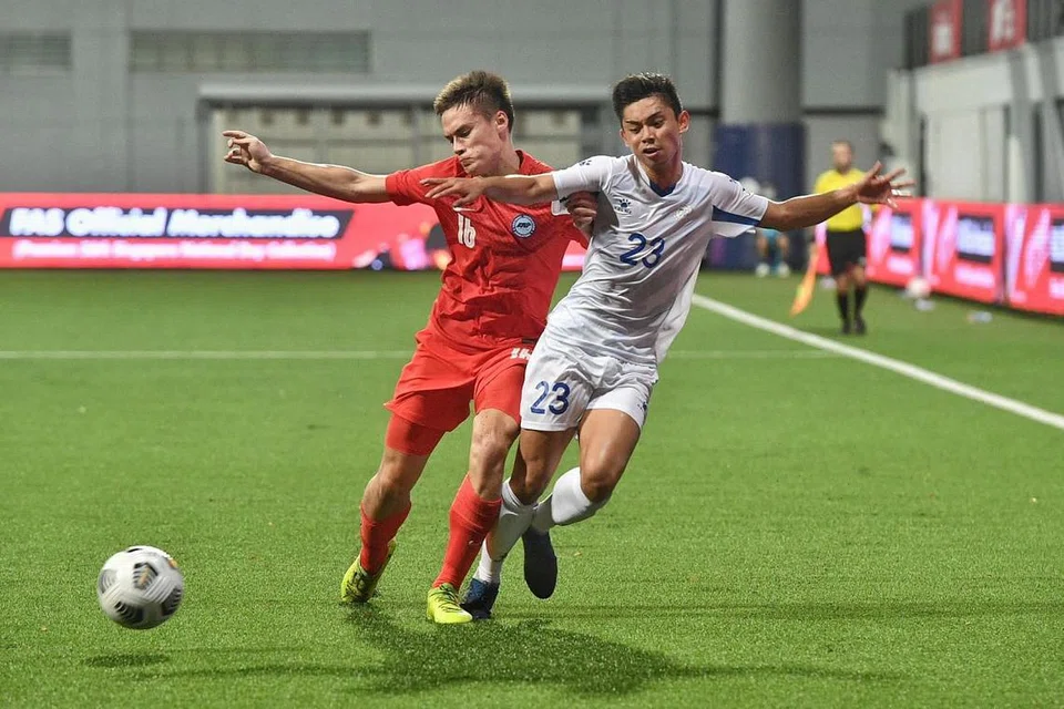 Pemain Singapura Ryhan Stewart (kiri) dan pemain Filipina Jethro Borlongan (kanan) bergelut dalam perlawanan Kelayakan Piala Asia U23 AFC di Stadium Jalan Besar malam ini. - Foto ARIFFIN JAMAR 