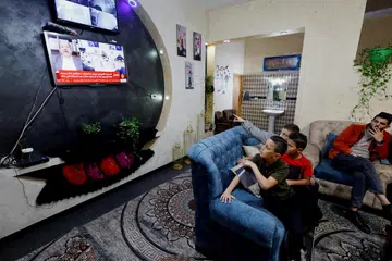 PERJANJIAN DICAPAI: Keluarga Palestin menonton di televisyen kemas kini berita mengenai tebusan Israel dan perjanjian pertukaran tahanan Palestin, di tengah-tengah konflik berterusan antara Israel dan kumpulan Islam Palestin Hamas, dekat Hebron di Tebing Barat. 