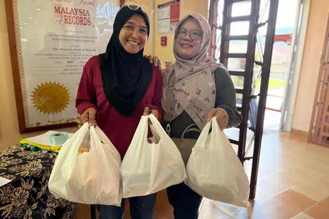 Cik Rohayu Abd Hamid (kanan) bersama rakannya teruja membeli kuih Raya dari penjara di Galeri Produk My Pride, di Penjara Kajang, Selangor. 