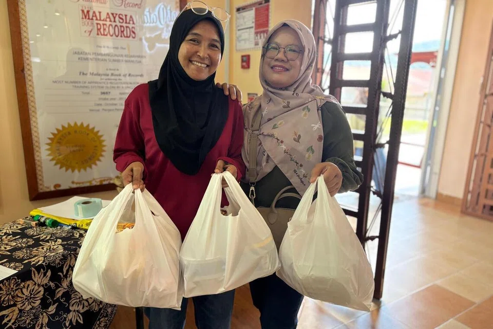 Cik Rohayu Abd Hamid (kanan) bersama rakannya teruja membeli kuih Raya dari penjara di Galeri Produk My Pride, di Penjara Kajang, Selangor. 