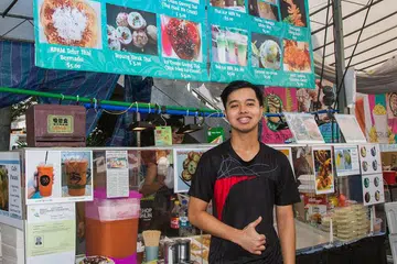 MEMBANTU KELUARGA: Encik Haq membantu mengendalikan Cafe Patani milik keluarganya di bazar Ramadan di Haig Road. - Foto ZALEHA ABDUL KADER