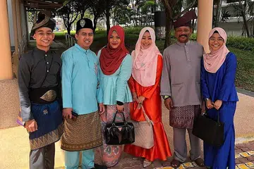MENGGAYAKAN PENDING: Syahzyad Syawqie Kamal Lutfie (kiri) menggayakan tanjak Lang Melayang Rendah bersama pending. Ditemani ibu dan bapanya Encik Kamal Lutfie (kedua dari kiri) dan Cik Siti Hajar (ketiga dari kanan) bersama kedua-dua kakak dan abang iparnya. - Foto ihsan SYAHZYAD SYAWQIE KAMAL LUTFIE