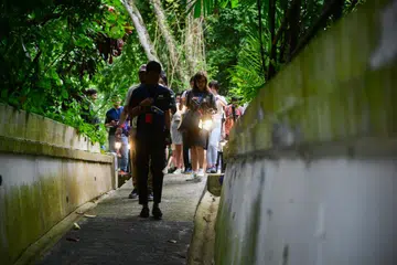 Peserta pada sesi pratonton media, ‘Lawatan Senja Fort Siloso’,  memegang pelita berkuasa bateri ketika menuruni kompleks terowong kubu itu pada 10 Februari.