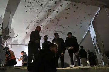 Penduduk Gaza memeriksa lokasi serangan udara Israel ke atas sebuah rumah di Khan Younis, selatan Jaluran Gaza, pada 7 Januari, di tengah-tengah perang yang sedang berlangsung di wilayah Palestin antara Israel dengan Hamas. 