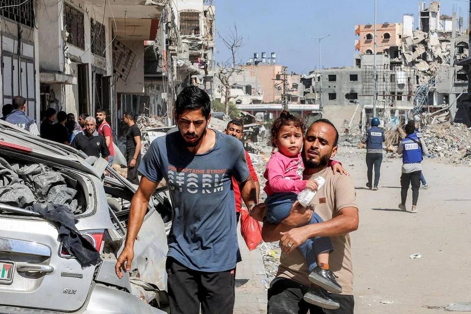 Seorang lelaki mendukung kanak-kanak ketika berpindah di kem Jabalia untuk pelarian Palestin di utara Gaza pada 9 Oktober sedang kumpulan Hamas dan Fattah  mengadakan rundingan mengenai pentadbiran pascaperang di Kahirah, Mesir pada 9 Oktober.