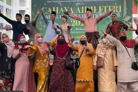 DEKATI MASYARAKAT: Encik Shahrin (barisan belakang tiga dari kiri) bersama Anggota Parlimen GRC West Coast Cik Foo Mee Har (barisan belakang, empat dari kiri) membuat persembahan bersama penduduk sempena majlis sambutan Hari Raya Aidilfitri anjuran MAEC Kelab Masyarakat Ayer Rajah . - Foto MAEC KELAB MASYARAKAT AYER RAJAH