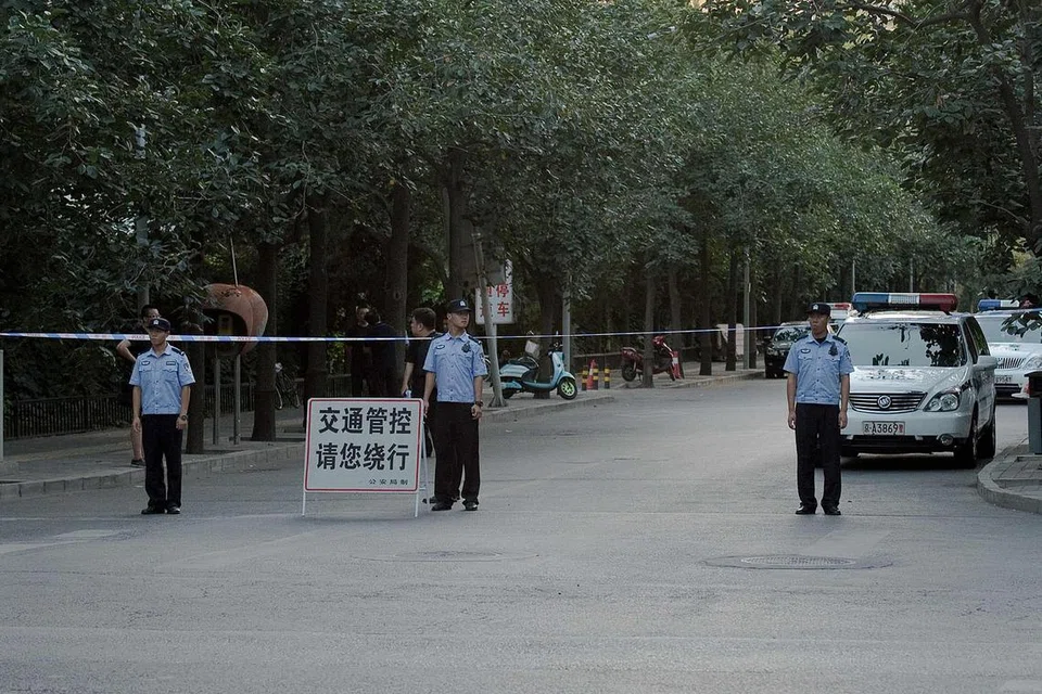 TUTUP LALUAN: Pegawai polis China melakukan sekatan jalan raya menuju Kedutaan Filipina di Beijing, kelmarin. - Foto-foto AFP 
