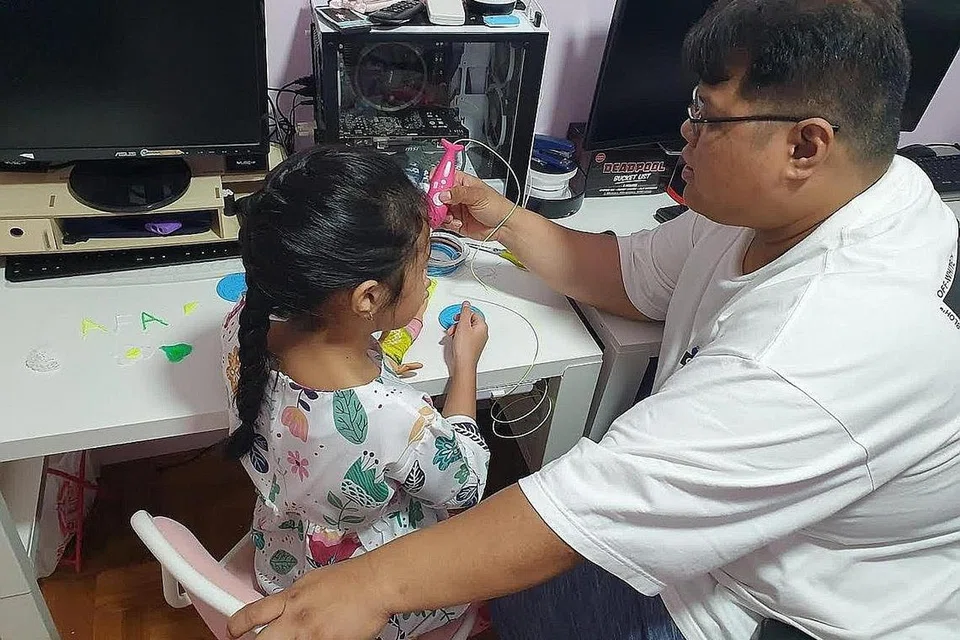 MEREKA AKSESORI UNIK: Aufa Qalesya (kiri), lapan tahun, gemar menggunakan pen 3D bersama ayahnya, Encik Mohammad Zahrin Abdullah, untuk mereka pelbagai aksesori untuk patungnya. - Foto ihsan MOHAMMAD ZAHRIN ABDULLAH