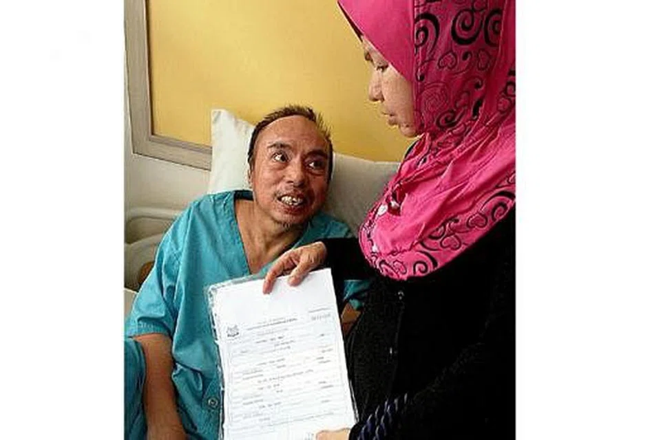 MENGGALAS MASALAH SEORANG DIRI: Cik Siin yang sering berulang-alik dari Batam ke sini bagi menziarahi suaminya, Encik Samat, di sebuah rumah penjagaan di Bukit Panjang, menunjukkan sijil lahir anak tirinya, Norhidayah, bagi membantu merungkaikan masalah yang dihadapinya. - Foto SAINI SALLEH 