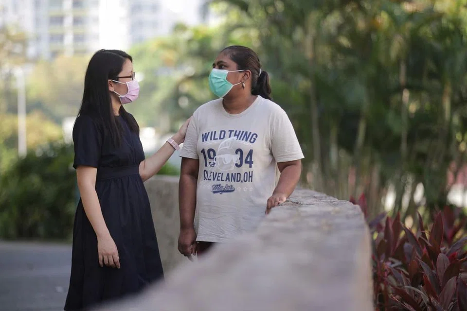 BERI SOKONGAN: Pekerja Sosial Kanan dari Program Pengurusan Kes Ketidakupayaan Minds, Cik Tay Yu Ping (kiri) berinteraksi dengan klien dari Minds, Cik Shantini Murugiah semasa acara laluan masyarakat di Taman Limbang semalam. - Foto BH oleh GIN TAY