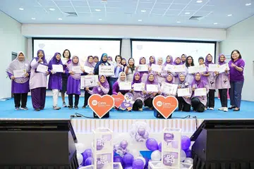 Anggota Parlimen (AP) GRC Sembawang, Cik Mariam Jaafar, (12 dari kiri) dan Setiausaha Tetap Kementerian Kebudayaan, Masyarakat dan Belia (MCCY), Cik Teoh Tsin Woon (10 dari kiri) bergambar bersama sukarelawan pusat penuaan aktif Blossom Seeds semasa acara The Purple Party pada 14 Disember.