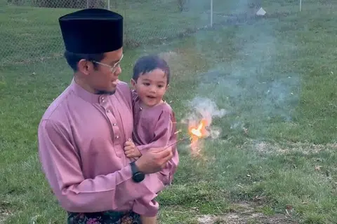 Encik Hilwan dan anaknya, Muhammad Akmal Muhammad Hilwan, ketika bermain mercun.