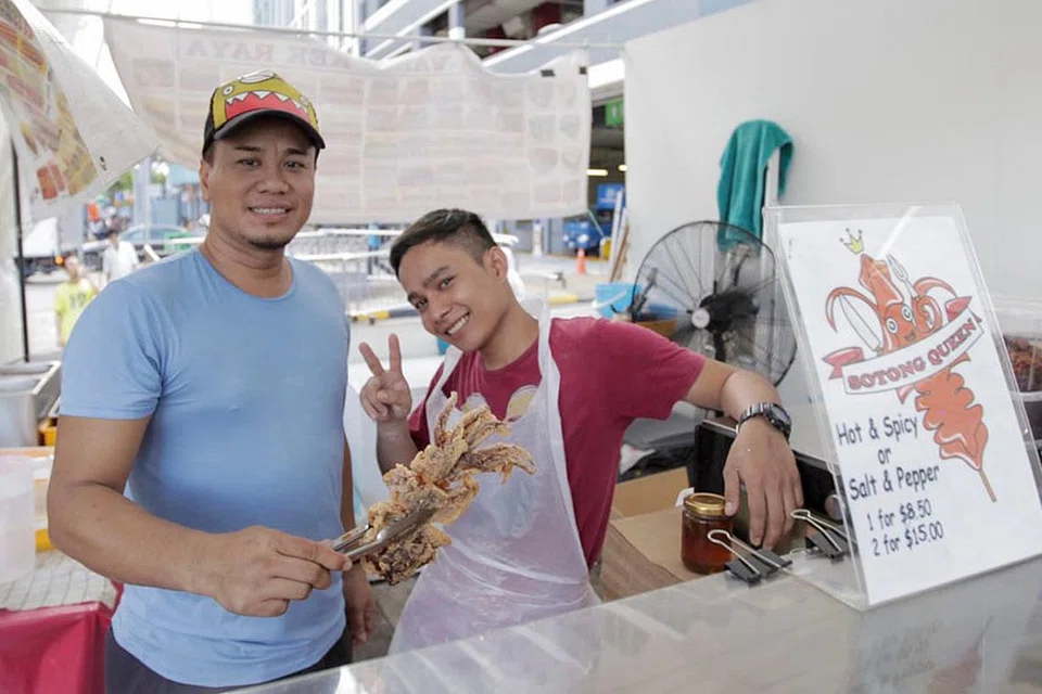 PELBAGAI PILIHAN: Selain daripada Sotong Goreng, Kek Lapis Sarawak dan Tapak Kuda dijual di gerai yang dikendalikan Daily Makan & Events. Am Cha (kiri) dan Danny (kanan), pekerja di Gerai Daily Makan & Events. - Foto BH oleh IQBAL FAISAL