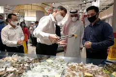 PELBAGAIKAN SUMBER: (Dari kiri) Encik Chan Chun Sing sedang meneliti produk udang yang diimport dari Arab Saudi, sambil diperhatikan oleh Duta Besar Arab Saudi ke Singapura, Encik Saad Al Saleh dan Encik Kenneth Chia, Pengarah Urusan The Seafood Company. - Foto BH oleh Ng Sor Luan