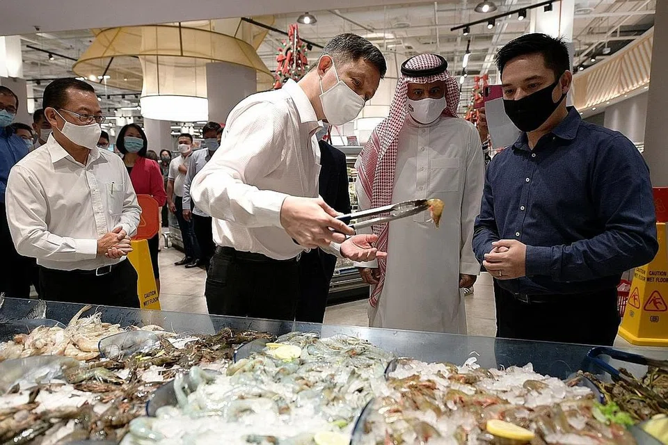 PELBAGAIKAN SUMBER: (Dari kiri) Encik Chan Chun Sing sedang meneliti produk udang yang diimport dari Arab Saudi, sambil diperhatikan oleh Duta Besar Arab Saudi ke Singapura, Encik Saad Al Saleh dan Encik Kenneth Chia, Pengarah Urusan The Seafood Company. - Foto BH oleh Ng Sor Luan