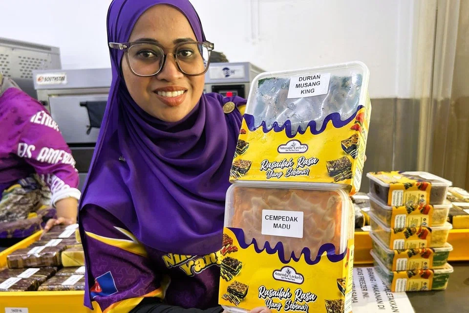 Cik Faizah Zakaria menunjukkan kuih lapis perisa Durian Musang King dan Cempedak Madu keluaran kilangnya di Pasir Gudang, Johor.