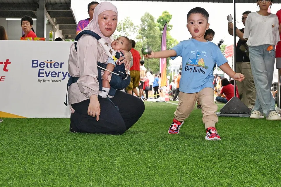 Cik Selene Tung, bersama anak-anaknya di sambutan Hari Kebangsaan 2025 di Yishun pada 10 Ogos.