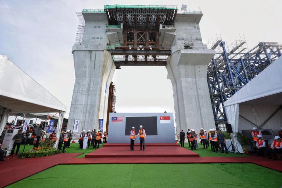 KERJASAMA LEBIH ERAT: Perdana Menteri Singapura, Encik Lee Hsien Loong (kanan, atas pentas) dan Perdana Menteri Malaysia, Datuk Seri Anwar Ibrahim berjabat tangan semasa menghadiri acara yang diadakan pada 11 Januari di tapak RTS Link Marine Viaduct di Selat Johor. 