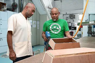 KELENGKAPAN BAGI PENGURUSAN JENAZAH: Encik Iskandar (kiri) melihat kakitangan, Encik Mohd Ramlee Mohd Ali, membuat papan long di kilang Singapore Muslim Casket & Marble Contractor yang terletak di Geylang Bahru. Syarikat itu dipercayai satu-satunya syarikat pengurusan jenazah Islam yang mempunyai kilang kecil untuk membuat papan long.