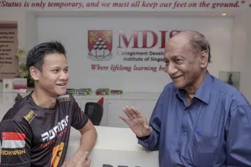 HARGAI SUMBANGAN MDIS: Encik Muhammad Ridhwan Ahmad (kiri) amat berterima kasih atas hadiah serta sokongan yang diberikan Institut Pembangunan Pengurusan Singapura (MDIS). Dr R. Theyvendran (kanan) berkata beliau yakin Encik Ridhwan boleh menjadi inspirasi kepada belia lain. - Foto BH oleh IQBAL FAIZAL
